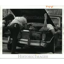 1988 Press Photo Automobile Repairs, Group inspects car engine issues