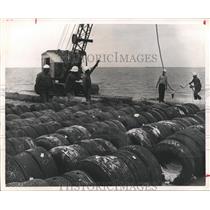 1990 Press Photo Men Working to Make Fishing Shelters Out of Old Auto Tires