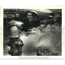 1987 Press Photo Poncho Williams cooling off in open fire-hydrant-S. Prieur St
