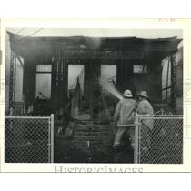 1989 Press Photo New Orleans firemen hose down the shell of a house. - nob14149