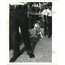 1992 Press Photo Richie Scheurman stands in the shadow of police and firemen.