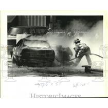 1994 Press Photo New Orleans Firefighters put out a fire in a Ford Taurus