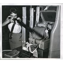 1955 Press Photo Paris woman trying out Double barreled shotgun in Paris Store