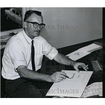 1960 Press Photo Commercial Artist Luis Turner on paperwork - orb97260