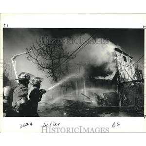 1991 Press Photo New Orleans Firemen extinguishing fire on1100 block, Melpomene