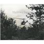 1975 Press Photo Helicopter searches thickly wooded area where bandits fled
