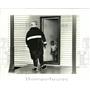 1986 Press Photo Marcellus Bron with fireman telling family they must evacuate