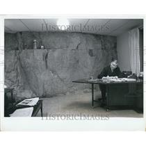 Press Photo A Man At His Desk In A Cave-Like Building