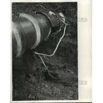 1970 Press Photo Fluid drains from large hole in pipe, pollution