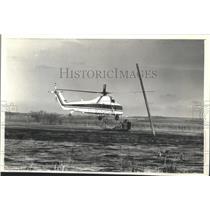 1990 Press Photo Helicopter hovers over water near Horizon Marsh's island